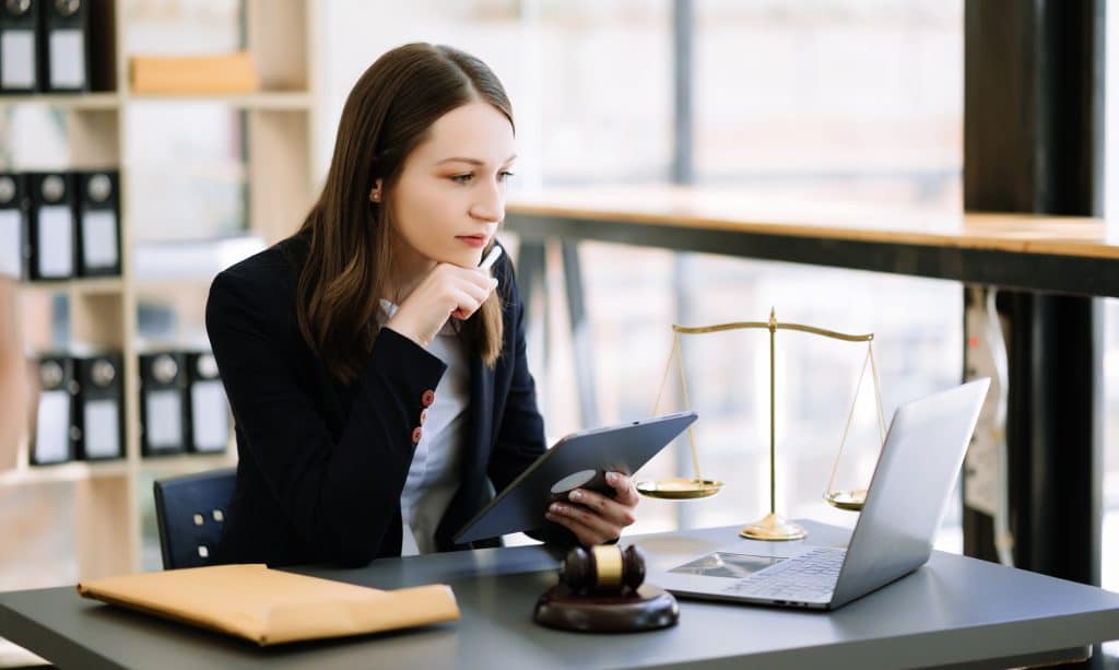 Woman lawyer working and gavel, tablet and laptop in front, Advice justice and law concept.